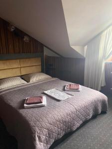 a bedroom with a bed with two trays on it at Rikabar Restaurant & nature in Bila Tserkva