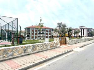 a stone wall next to a street with a building at Theos Holiday Apartments Room 23 Family Suit Accommodation For Families Only in Kuşadası