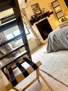 a bedroom with a bunk bed and a fireplace at The Old Thatch - Hennock in Newton Abbot