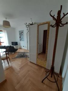a living room with a mirror and a wooden floor at Vittadinisette in Pavia +6 photos
