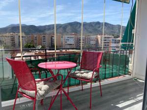 einen roten Tisch und Stühle auf einem Balkon mit Aussicht in der Unterkunft LaFrenchTouch - Coqueto estudio terraza con vistas in Torremolinos