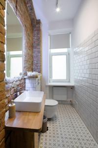 La salle de bains est pourvue d'une grande baignoire blanche et de toilettes. dans l'établissement Brivibas House Design Apartments In City Center, à Riga