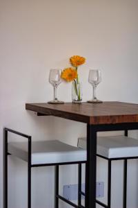 a table with two glasses and a vase with flowers on it at Casa Mel in Puducherry