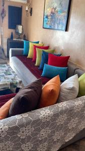 un sofá con almohadas coloridas en una habitación en Havre de paix pied dans l'eau, en Agadir