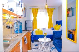 Habitación pequeña con lavabo y cama con cortinas amarillas. en Enac Homes - Classy, Elegant Executive Studios - Kiambu Road en Kiambu