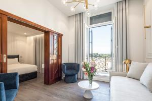 uma sala de estar com um sofá, uma cama e uma janela em Bella Venezia em Corfu Town