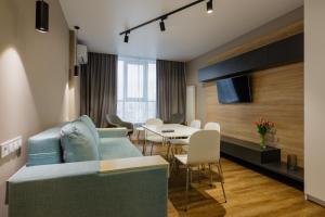 a living room with a blue couch and a table at Studio VIKTORY 5 В, 21 floor, Kyiv in Kyiv