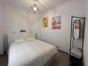 Habitación blanca con cama y espejo en HJS Guest House - The majestic Loft, en Las Palmas de Gran Canaria