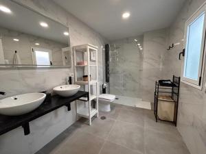 a bathroom with two sinks and a shower and a toilet at HJS Guest House - The majestic Loft in Las Palmas de Gran Canaria