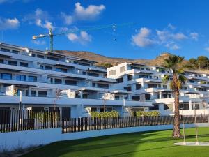 a white building with a palm tree in front of it at Apartment Seascape Relax in Finestrat