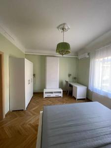 a bedroom with a bed and a desk and a window at Guest house, Jūrmala in Jūrmala