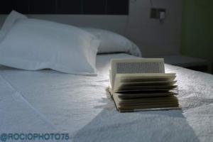 a stack of books sitting on top of a bed at Rapadoira Seaside Apartment in Foz