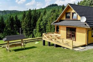 eine Holzhütte mit einer Bank und einem Frisbee in der Unterkunft Domek w Klisiówkach in Ujsoły