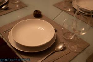 a plate and two wine glasses on a wooden table at Rapadoira Seaside Apartment in Foz