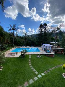 a large swimming pool in a yard with a grass field at Hotel La Bella Toscana - Exclusive Hotel in Águas de Lindoia