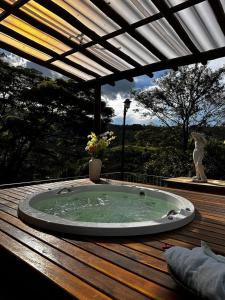 Hotel La Bella Toscana - Exclusive Hotel في أغواس دي يندويا: حوض استحمام ساخن على سطح خشبي مع عفش