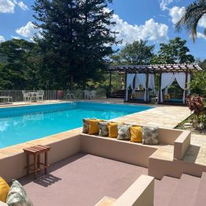 una piscina con un banco frente a una piscina en Hotel La Bella Toscana - Exclusive Hotel, en Águas de Lindóia