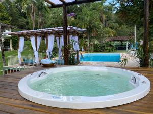 bañera de hidromasaje en una terraza de madera con pérgola en Hotel La Bella Toscana - Exclusive Hotel en Águas de Lindóia