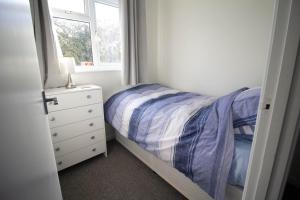 a bedroom with a bed and a dresser and a window at Lovely 5 Berth Chalet In The Coastal Village Of Hemsby Ref 18164b in Hemsby