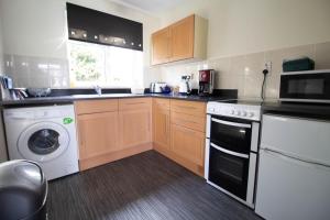 a kitchen with a washing machine and a washer at Lovely 5 Berth Chalet In The Coastal Village Of Hemsby Ref 18164b in Hemsby