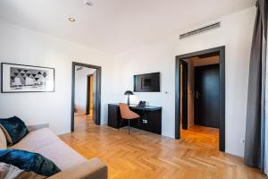 a living room with a couch and a desk at Miramare Hotel in Zadar