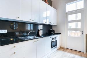 巴塞隆納的住宿－Gracia15，厨房配有白色橱柜、水槽和窗户。
