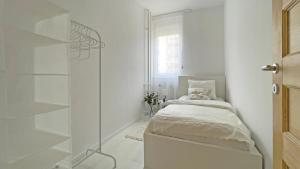 a white room with a bed and a glass shower at Eliza Apartman Veszprém in Veszprém