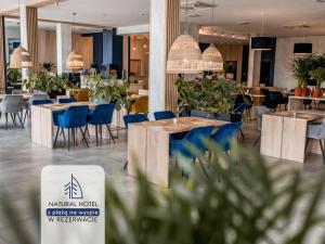 restauracja ze stołami i krzesłami w pokoju w obiekcie Natural Hotel w Rezerwacie z Plażą Na Wyspie w Ostródzie