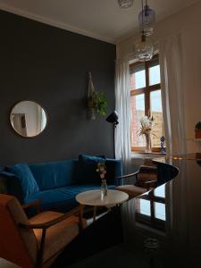 een woonkamer met een blauwe bank en een tafel bij Kraków Piano Apartment in Krakau