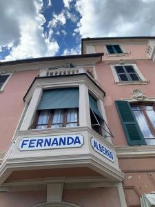a facade of a pink building with a sign on it at Hotel Fernanda in Rapallo