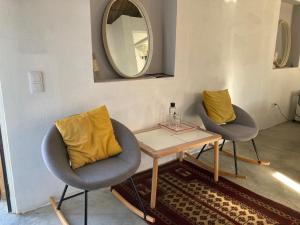 塔維拉的住宿－Yoga Farm，一间设有两把椅子、一张桌子和一面镜子的房间