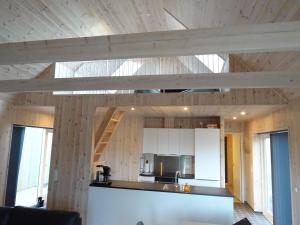 a kitchen with wooden walls and a wooden ceiling at Captains Cottage in Sandur