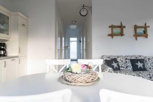 een witte eetkamer met een witte tafel en stoelen bij Villa Marin Wohnung 25 in Zinnowitz