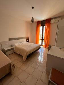 a bedroom with a bed and a large window at Appartamenti Aspromonte in Milan