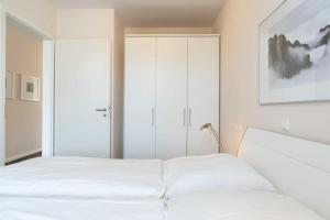1 dormitorio con cama blanca y armario en Villa Marin Wohnung 24 en Zinnowitz