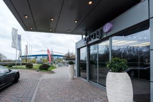 ein Autohaus mit zwei großen Vasen vor einem Gebäude in der Unterkunft stays by friends Gelsenkirchen in Gelsenkirchen