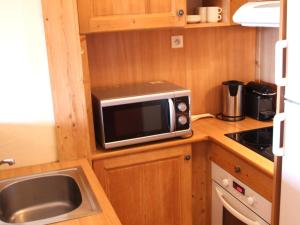 a small kitchen with a microwave and a sink at Appartement Montagne pour 6 pers, proche télécabine - FR-1-165A-53 in Uvernet-Fours +4 photos