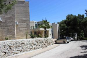 Samochód stoi obok kamiennej ściany. w obiekcie The Bridgettine Sisters Monastery w Jerozolimie