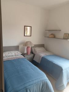 1 dormitorio con 2 camas y lámpara. en Mont'Isoro en Orgosolo