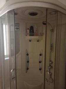 een badkamer met een douche en een glazen deur bij Mont'Isoro in Orgosolo