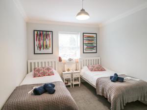 Un dormitorio con dos camas y una ventana. en 9A Wick Lane, en Christchurch
