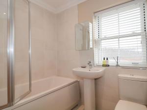 Un baño con lavabo, bañera e inodoro. en 9A Wick Lane, en Christchurch 22 fotos más