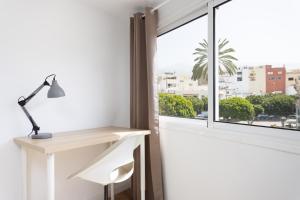 a desk and a lamp in a room with a window at 150 Chill and sun Alcala By Sunkeyrents in Alcalá