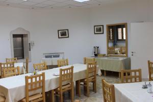 jadalnia z białymi stołami i drewnianymi krzesłami w obiekcie The Bridgettine Sisters Monastery w Jerozolimie