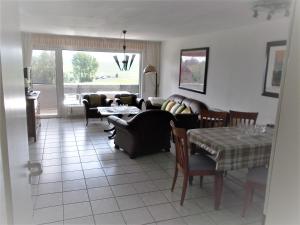 a living room with a couch and a table and chairs at Haus Bergeshöh Hochsauerland in Eslohe