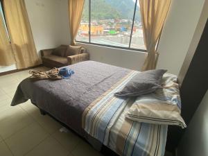 a bed in a room with a large window at GIGAHOUSE in Baños