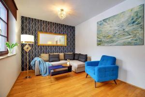 sala de estar con sofá y silla azul en Apartamenty Sun Seasons 24 - Rezydencja Pod Świerkami Centrum, en Karpacz