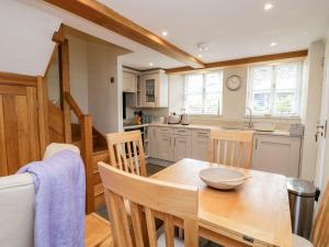 a kitchen with a wooden table and a dining room at Jessamine Cottage in Ambleside