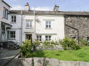 a white house with a fence in front of it at Jessamine Cottage in Ambleside