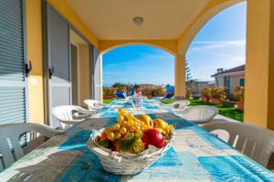 una mesa con un bol de fruta en ella en Villa Mimosa Diano Marina: exclusive use villa, garden, barbecue, 3 bedrooms and 3 bathrooms, en Diano Marina